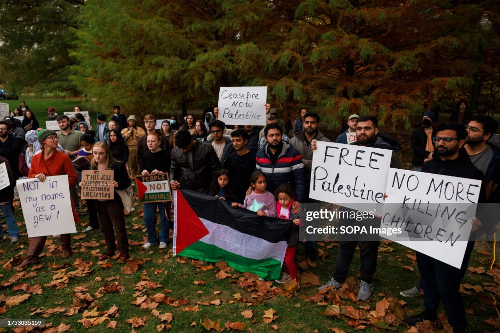 Protesters holding placards gather in Dunn Meadow at Indiana...