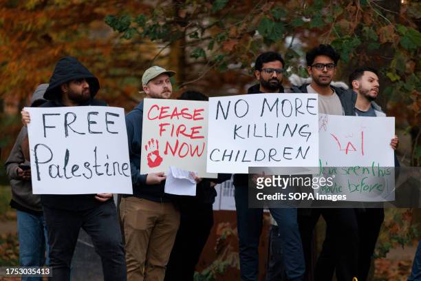 Protesters hold placards in Dunn Meadow at Indiana University to protest against the Israeli ground operation into Gaza. The rally was titled, "Stand...
