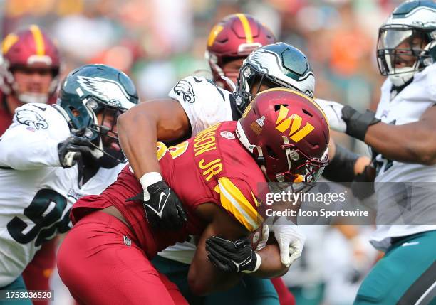 Philadelphia Eagles linebacker Nakobe Dean and defensive end Derek Barnett tackle Washington Commanders running back Brian Robinson Jr. During the...