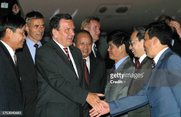 German Chancellor Gerhard Schroeder is greeted by Vietnamese officials upon his arrival at Hanoi airport, 14 May 2003. Schroeder arrived from...