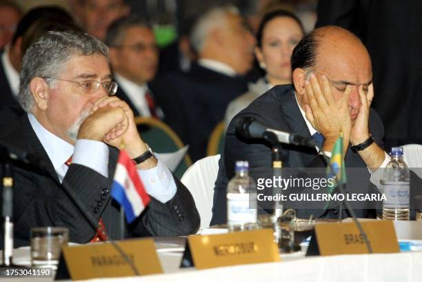 Argentinian chancellor Carlos Rackauf rests his head on his hands flanked by his Brazilian collegue Celos Lafer, during the VII ministerial meeting...