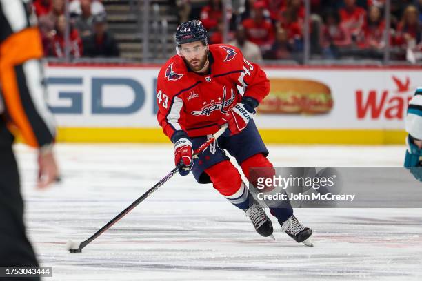 Tom Wilson of the Washington Capitals skates the puck up the ice during a game against the San Jose Sharks at Capital One Arena on October 29, 2023...