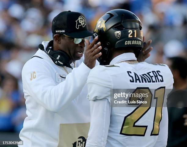 Pasadena, CA - Colorado coach Deon Sanders talks with his son, Colorado defensive back Shilo Sanders, before the game against UCLA at the Rose Bowl...