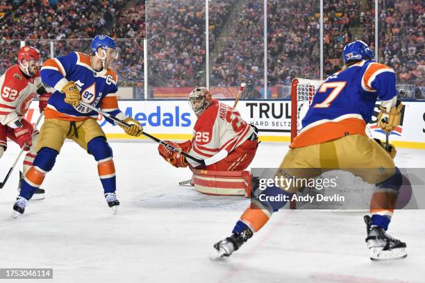 Jacob Markstrom of the Calgary Flames and Connor McDavid of the Edmonton Oilers truck the puck behind the net at the 2023 Tim Hortons NHL Heritage...