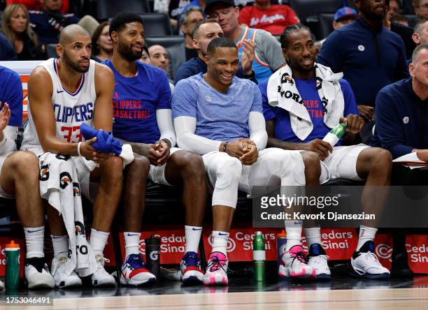 Russell Westbrook, Paul George, and Kawhi Leonard of the Los Angeles Clippers laugh on the bench after coming out of the game against the San Antonio...