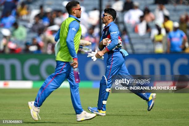 Afghanistan's Rahmanullah Gurbaz prepares for wicketkeeping after his teammate Ikram Alikhil got injured during the 2023 ICC Men's Cricket World Cup...