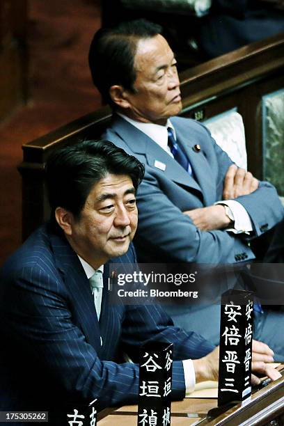 Shinzo Abe, Japan's prime minister, left, and Taro Aso, Japan's deputy prime minister and finance minister, attend a plenary session at the lower...