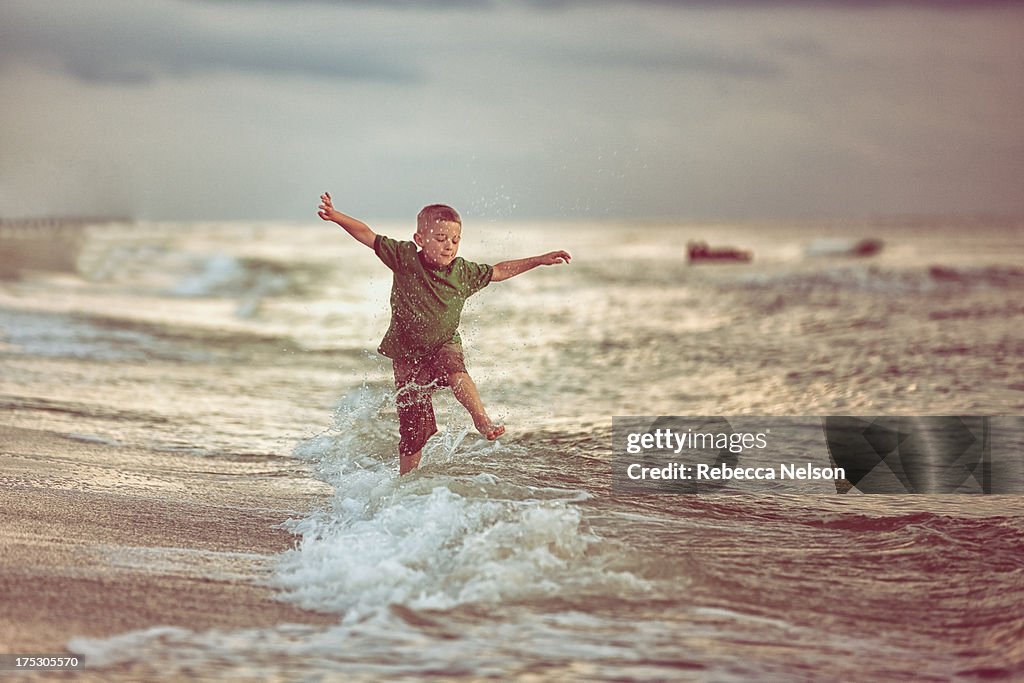 Boy jumping over waves