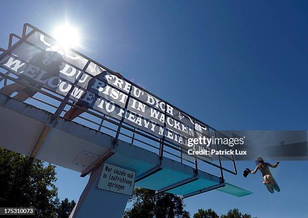 Visitors enjoy a bath in the public open-air swimming pool at the Wacken Open Air heavy metal music fest on August 2, 2013 in Wacken, Germany....