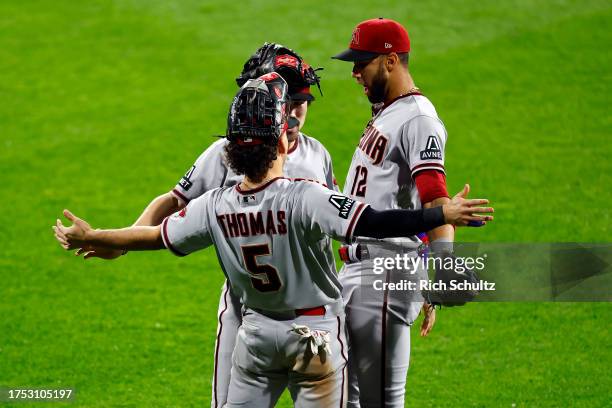 Corbin Carroll, Alek Thomas and Lourdes Gurriel Jr. #12 of the Arizona Diamondbacks celebrate after defeating the Philadelphia Phillies during Game...