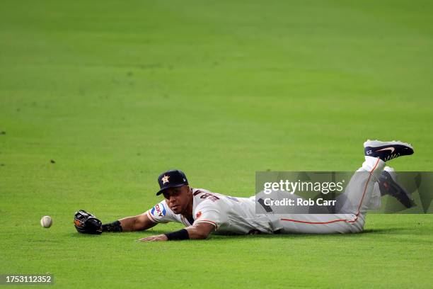 Michael Brantley of the Houston Astros misses a catch hit by Mitch Garver of the Texas Rangers to score Adolis Garcia during the first inning in Game...