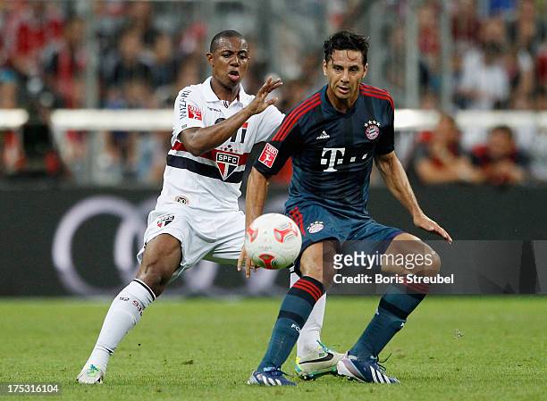 Claudio Pizarro of Muenchen is challenged by Wellington of Sao Paulo during the Audi Cup 2013 semifinal match between FC Bayern Muenchen and FC Sao...