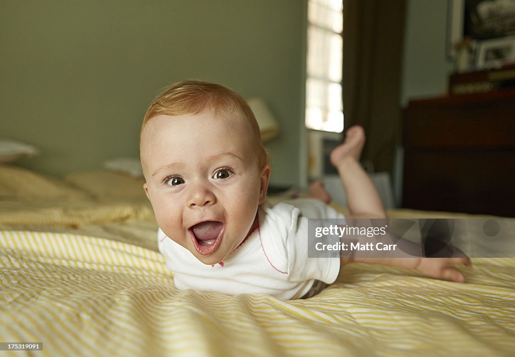 Baby laughing on bed