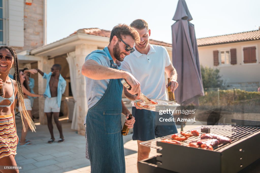 Hispanic Male Grilling Delicious BBQ by the Villa Pool