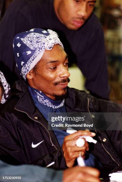 Rapper Snoop Dogg signs autographs and greets fans at George's Music Room in Chicago, Illinois in November 1996.