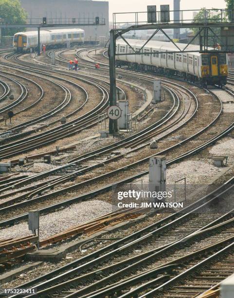 Railway employees work on the tracks leading from Victoria Station in London 05 August, 2003 during a heat wave that has forced trains to reduce...