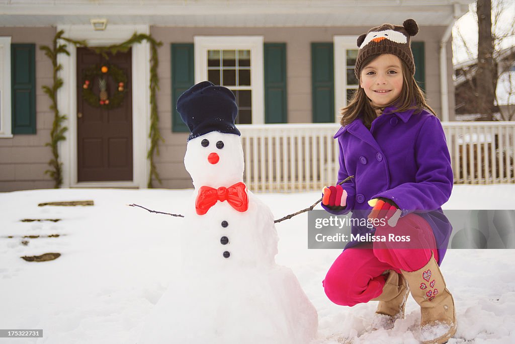 Portrait of a girl holding hands with a snowman.