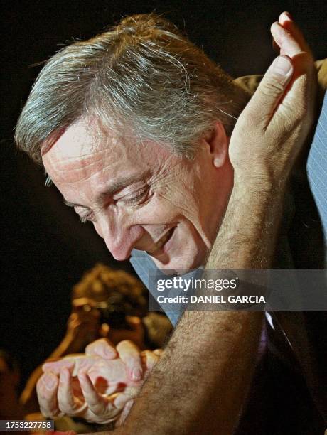 El candidato presidencial del Frente para la Victoria, Nestor Kirchner recibe el saludo de sus partidarios, el 22 de abril de 2003 durante un acto de...