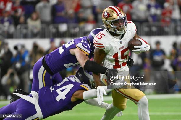 Jauan Jennings of the San Francisco 49ers battles for yards after a first half catch against Camryn Bynum and Harrison Smith of the Minnesota Vikings...