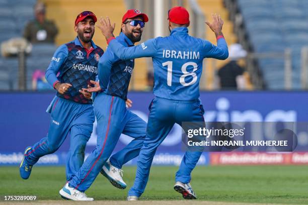 Afghanistan's Rashid Khan celebrates with teammates after taking a catch to dismiss Sri Lanka's Charith Asalanka during the 2023 ICC Men's Cricket...