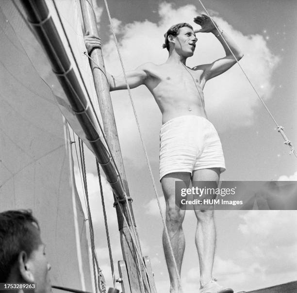 Man in swimming trunks standing next to a mast ca: 1946.