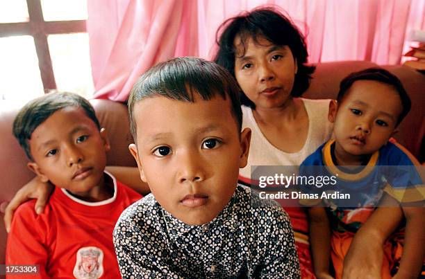 Garil Arnanda Dwiga Meza Endang Isnaini and Izul Haq pose in their living room of their home January 30, 2003 in Denpasar, Bali, Indonesia. Endang is...
