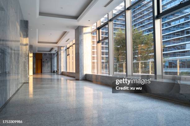 sunlight shines on office corridor - korridor stock-fotos und bilder