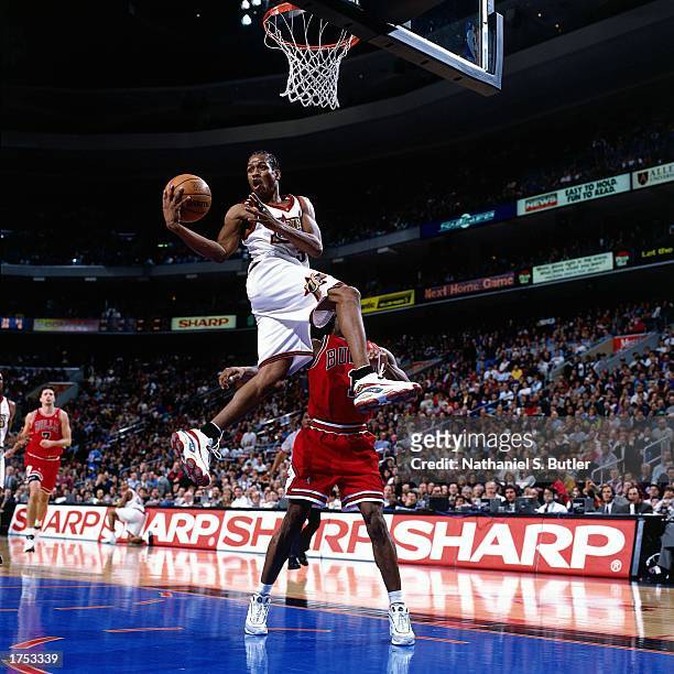 Allen Iverson of the Philadelphia 76ers looks to pass as he drives to the basket against the Chicago Bulls at the First Union Center during the 1998...