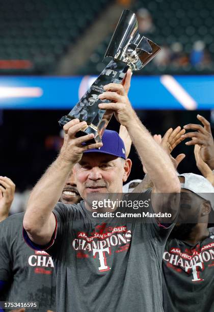 Manager Bruce Bochy of the Texas Rangers hoist the William Harridge Trophy after defeating the Houston Astros in Game Seven of the American League...