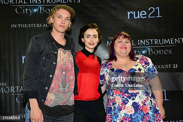 Actors Jamie Campbell Bower and Lily Collins pose with author of THE MORTAL INSTRUMENTS Cassandra Clare at the Franklin Mills Mall and sign...