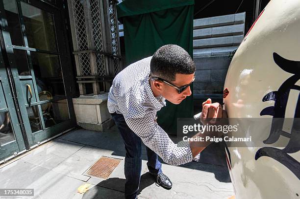 American League All-Star Manny Machado of the Baltimore Orioles signs the American League All-Star Game apple during the 2013 All-Star Red Carpet...