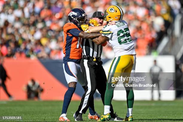 Referee works to separate cornerback Keisean Nixon of the Green Bay Packers and wide receiver Jerry Jeudy of the Denver Broncos after a first quarter...