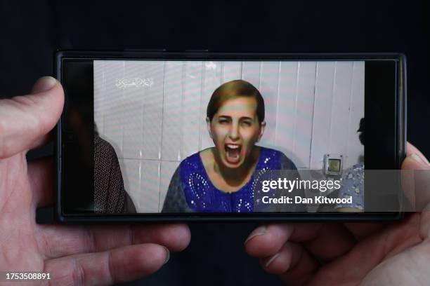 In this photo illustration, a phone displays footage released by Hamas today showing Danielle Aloni , one of a group of three hostages purportedly...