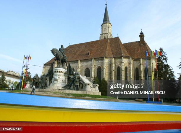 General view of the statue of Matei Corvin in the front of the St Michael Cathedral surrounded by Romanian flags in the central Unirii square of Cluj...