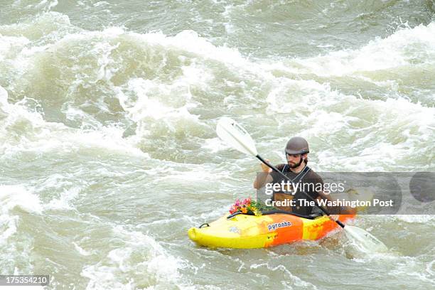 Joe Sullivan of Oneonta, New York, paddles in the Potomac River with flowers resting on his kayak in order to commemorate the loss of Shannon Christy...