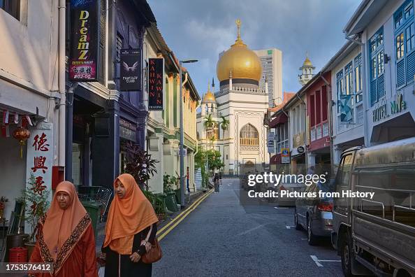 Singapore: Muslim women in Kampong Glam, traditionally a Malay / Muslim area of the city-state, in the background, the iconic Sultan Mosque, a national monument