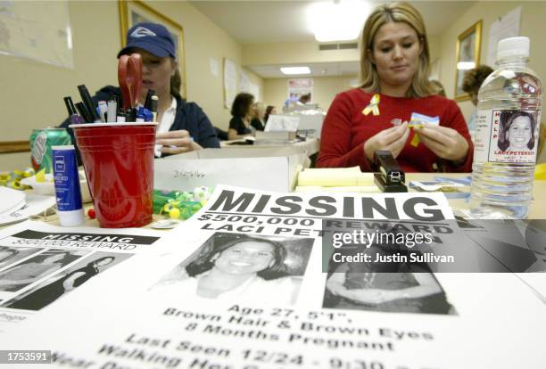 Volunteer Stacey Boyers folds yellow ribbons near a bottle displaying a label with a picture of the missing Laci Peterson January 4, 2003 in Modesto,...