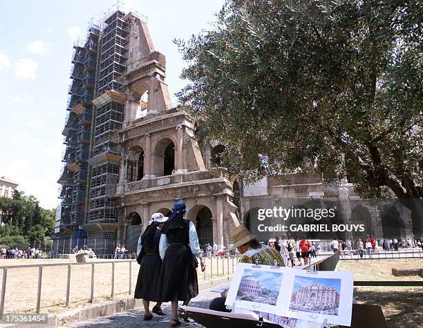 Un peintre vend ses aquarelles le 19 juillet 1999 devant le Colisée en partie masqué par un échafaudage. De nombreux travaux sont effectués à Rome et...