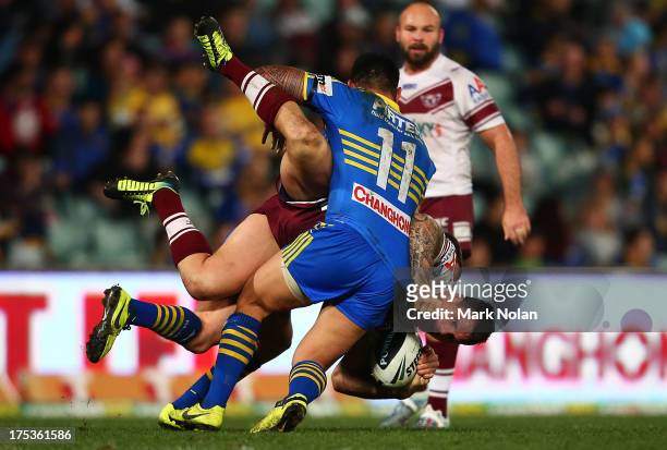 Anthony Watmough of the Eagles is tackled by Reni Maitua of the Eels during the round 21 NRL match between Parramatta Eels and the Manly Sea Eagles...