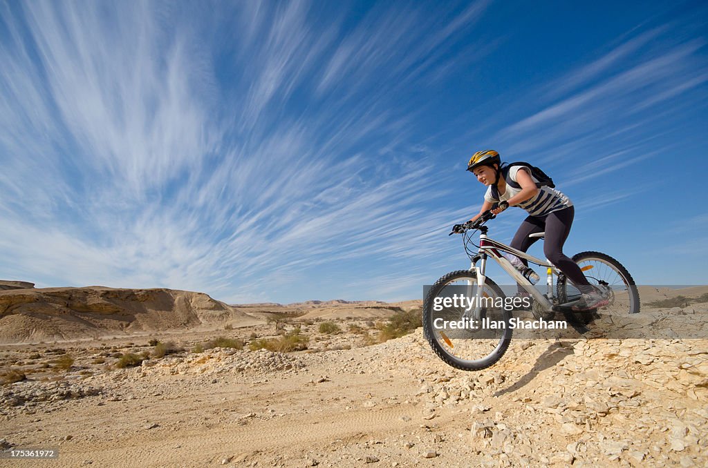 Teenage girl jumping on a mountain bike