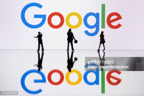 This illustration photograph taken on October 30 in Mulhouse, eastern France, shows figurines next to a screen displaying a logo of Google, a US...