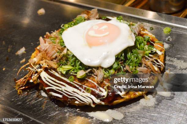 okonomiyaki cooked on a teppan - präfektur osaka stock-fotos und bilder