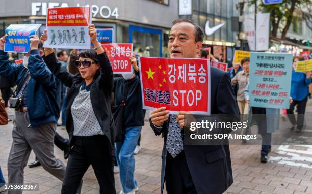 South Korean activists and North Korean defectors hold placards during a protest and march near the Chinese Embassy in Seoul, demanding an end to the...
