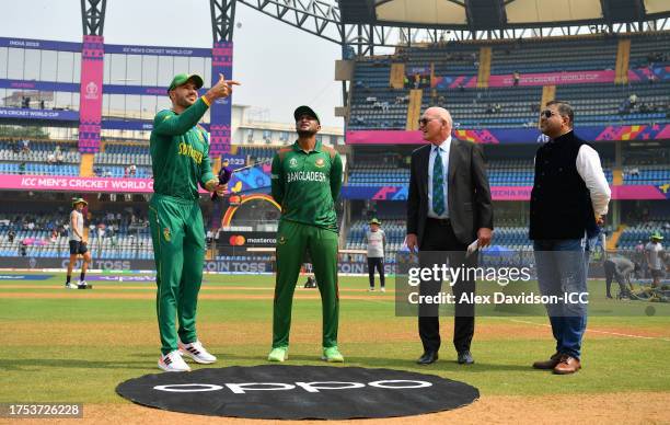 Aiden Markram of South Africa flips the coin as Shakib al Hasan of Bangladesh looks on ahead of the ICC Men's Cricket World Cup India 2023 between...