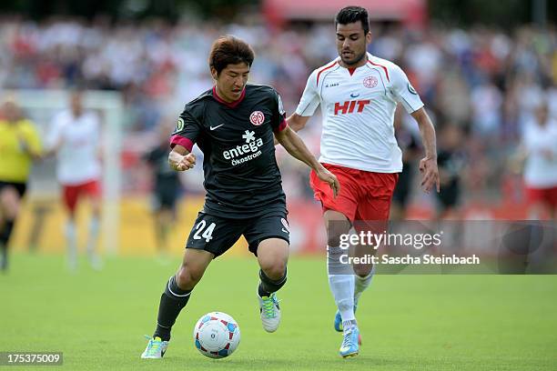 Joo-Ho Park of Mainz battles for the ball with Ozan Yilmaz of Koeln during the DFB Cup first round match between Fortuna Koeln and FSV Mainz 05 at...