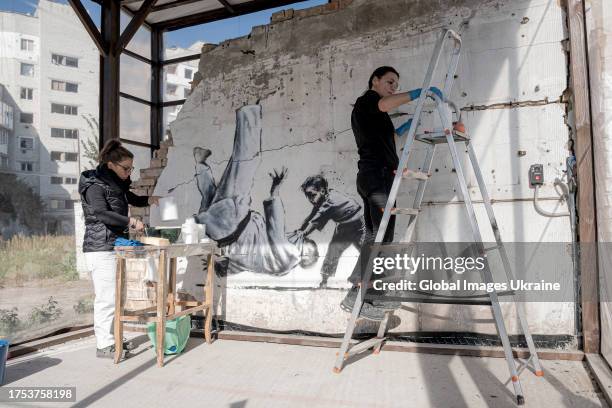 Italian conservation specialists carry out conservation work on the Banksy's mural on October 10, 2023 in Borodyanka, Kyiv Oblast, Ukraine. Within...