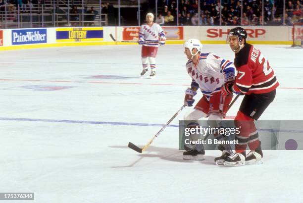 Scott Niedermayer of the New Jersey Devils follows Kevin Lowe of the New York Rangers on December 26, 1993 at the Madison Square Garden in New York,...