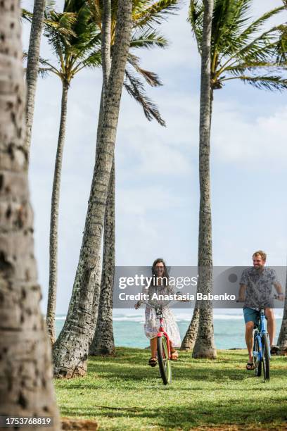 young couple on bicycles on a summer day - hawaii islands stock pictures, royalty-free photos & images