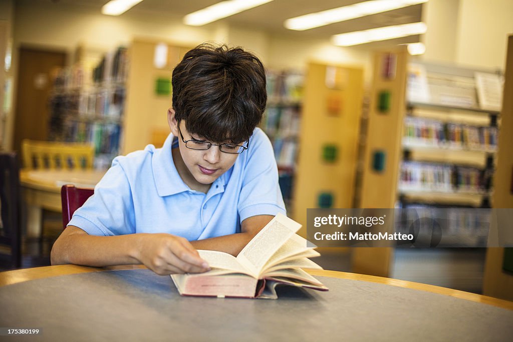 Handsome teenage boy in the library