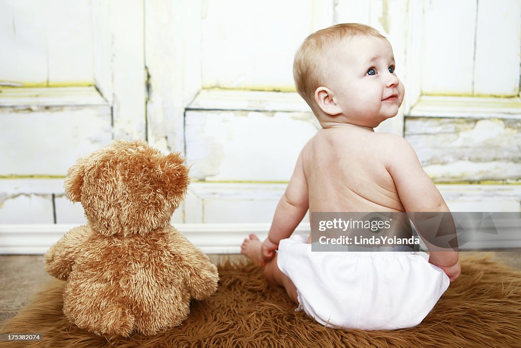 Baby sitzend mit Teddybär